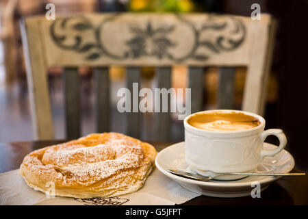 Horizontale Nahaufnahme von einer Tasse Kaffee und traditionellen Ensaimada oder Ensaïmada in einem Café, Mallorca. Stockfoto