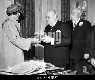 Die Bürgermeisterin von Poole (Dorset), die Bürgermeisterin Margaret Mary Lllewellin, überreicht Premierminister Sir Winston Churchill eine Schatulle, in der die Bescheinigung über seine Aufnahme als Freeman des Bezirks Poole enthalten ist. Die Zeremonie wurde im Salon der Downing Street 10, London, durchgeführt. Stockfoto