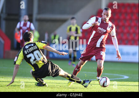 Kaid Mohamed von Cheltenham Town und Antony O'Connor von Burton Albion während des Spiels npower Football League Two im Abbey Business Stadium, Cheltenham. Stockfoto