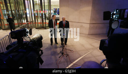 BBC-Generaldirektor George Entwistle (links) sieht zu, wie der Vorsitzende des BBC Trust Lord Patten vor dem BBC Broadcasting House in London mit den Medien spricht, nachdem Herr Entwistle seinen Rücktritt wegen der "inakzeptablen" Newsnight-Sendung angekündigt hatte, die fälschlicherweise einen älteren ehemaligen Konservativen in einen Kindesmissbrauch-Skandal verwickelt hatte. Stockfoto