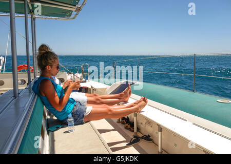 Junges Paar auf Katamaran, ein Drink auf Segelboot Tour, entspannen und genießen Sonne, Malaga, Andalusien, Spanien. Stockfoto