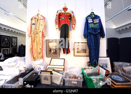 Formel-1-Fahreranzüge werden vor einer Auktion mit Erinnerungsstücken aus dem Sport im Sotheby's, London, ausgestellt. Stockfoto