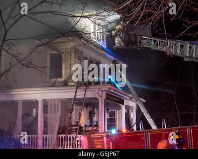 Chappaqua, New York - 11. April 2014: Feuerwehrleute aus Chappaqua und mehreren umliegenden Städten in Westchester County New York Kampf ein Feuer in einem Gebäude, das Whispering Pines Blumengeschäft und Wohnungen in Chappaqua, New York. Das Feuer begann um 01:00 Freitag Vormittag und ab 05:30 war das Feuer immer noch, mit starker Rauchentwicklung bedeckend die Umgebung. © 2014 Marianne A. Campolongo Stockfoto