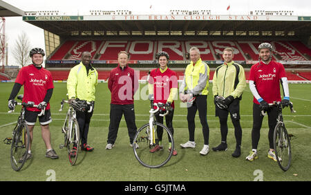 Nottingham Forest Manager Sean O'Driscoll mit Mitgliedern seines hinteren Raumstabes, First Team Coach Jimmy Floyd Hasselbaink, Torwarttrainer Paul Barron und Trainer Nathan Beardsley mit den Radfahrern Rowan Staszkiewicz, Scott Wilson und Matthew Vincent Pitchside vor ihrer 26-Meilen-Radtour vom City Ground Nottingham zum King Power Stadium, Leicester, um Geld für Prostatakrebs UK und die Alzheimer-Gesellschaft zu sammeln. Stockfoto