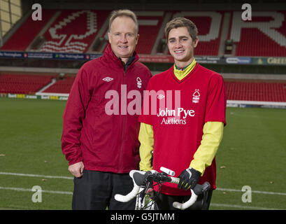 Nottingham Forest Manager Sean O'Driscoll mit dem Radfahrer Rowan Staszkiewicz Pitchside vor seiner 26 Meilen langen Radtour vom City Ground, Nottingham zum King Power Stadium, Leicester, um Geld für Prostate Cancer UK und die Alzheimer Society zu sammeln. Stockfoto