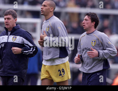 Robbie Fowler von Leeds United (rechts) wärmt sich mit seinen neuen Teamkollegen Rio Ferdinand (Mitte) und Trainer Brian Kidd vor dem Barclaycard Premiership-Spiel gegen Fulham im Craven Cottage, London, auf. Stockfoto