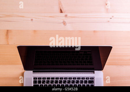 Laptop Layid auf hölzernen Schreibtisch. Studio gedreht. Stockfoto