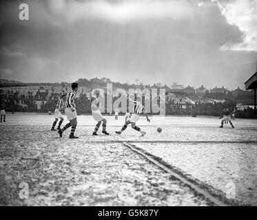 Gerry Summers (Nr. 6) läuft während des Spiels von West Bromwich Albion in der First Division gegen Charlton Athletic im Londoner Valley über das schneebedeckte Spielfeld. Auf der linken Seite befindet sich Ronnie Allen (Nr. 10). Stockfoto