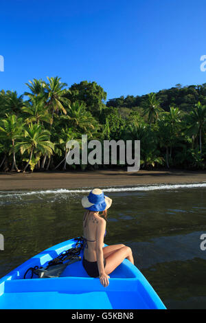 Hispanic Frau sitzt im Boot in der Nähe von Strand Stockfoto