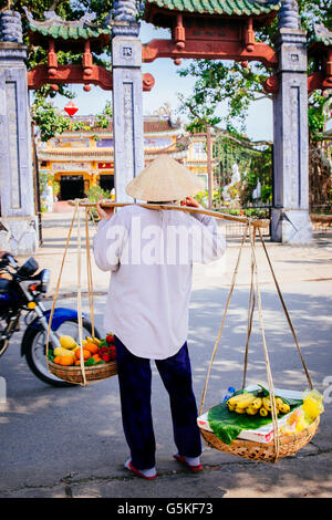 Verkäufer trägt Obstkörbe auf Stadt Bürgersteig Stockfoto