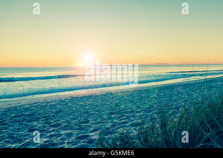 Rückwirkung Küsten breiten Bild Blick auf das Meer und den Sonnenaufgang am Horizont. Stockfoto