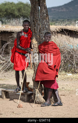 Zwei junge Männer stehen in einem Massai-Dorf in Masai Mara, Kenia, Afrika. Stockfoto