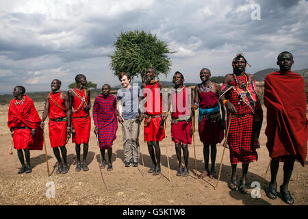 Gruppe der Masai-Krieger und ein Tourist ein zeremonieller Tanz in einem Masai Dorf, Kenia, Afrika zu tun. Stockfoto