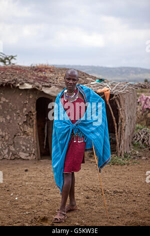 Masai Krieger steht man vor einer Lehmhütte in der Masai Dorf, Kenia, Afrika. Stockfoto