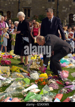 Königin Elizabeth II. Und der Herzog von Edinburgh in Begleitung des Superintendenten von Windsor Castle, Munro Davidson (Mitte), sehen Sie sich Blumen an, die im Schlossgelände von den Wasserschwängern zu Ehren des Todes von Königin Elizabeth, der Königin Mutter, in der letzten Woche hinterlassen wurden. Stockfoto