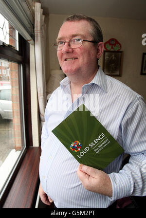 Bill McKnight, mit seinem Gedichtband Loud Silence, in seinem Zuhause in Belfast. Stockfoto