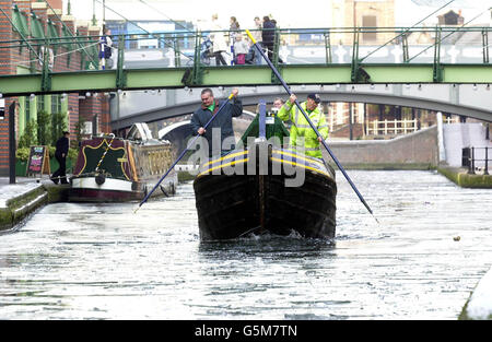 Das Barnett, das Eisbrecherboot der British Waterways, fährt am Brindley Place in Birmingham durch das Eis. Mit traditionellen Schmalbooten mit V-förmigem Bug brechen Teams von Ingenieuren Eisschwaden auf, die Teile des britischen 2,000-Meilen-Kanalnetzes eingefroren haben. Stockfoto