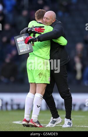 Milton Keynes Dons Torwart David Martin (links) umarmt Torwarttrainer Paul Heald (rechts) nach dem Schlusspfiff Stockfoto