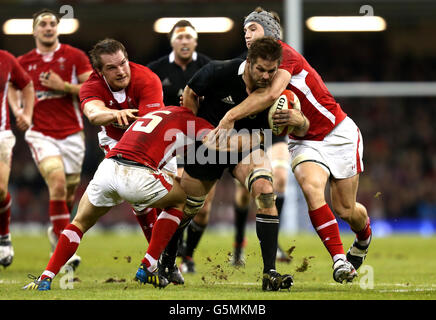 Die Neuseeländerin Richie McCaw wird von den Wales Leigh Halfpenny, Jonathan Davies und Gethin Jenkins während des Spiels der Dove Men Series im Millennium Stadium, Cardiff, angegangen. Stockfoto