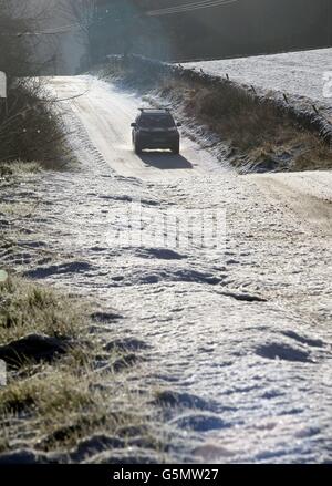 Ein Fahrzeug fährt entlang einer schneebedeckten Straße in den schottischen Grenzen, nachdem Schnee über Teile des Landes gefallen ist, mit mehr über das Wochenende vorhergesagt. Stockfoto
