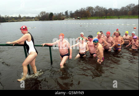 Schwimmer machen sich am Dienstag, den 25. Dezember 2001, nach dem jährlichen Schwimmen am Weihnachtstag, den Weg aus dem Serpentine Lake im Londoner Hyde Park. Die Schwimmer wetteiferten um den Peter Pan Cup mit rund 35 Mitgliedern des Schwimmclubs am Hyde Park Lake, die an der 100-Meter-Veranstaltung teilnahmen, die seit 1864 jedes Jahr stattfindet. Für dieses Jahr wurden Wassertemperaturen von bis zu 1C prognostiziert. Stockfoto