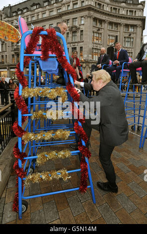 Boris Johnson, der Bürgermeister von London, steigt am Oxford Circus auf einen hohen Stuhl, wobei die Einzelhändler im West End für den Shop West End Day werben, an dem die Oxford Street und die Regent Street am Samstag, den 24. November, für den gesamten Verkehr gesperrt werden, um Weihnachtseinkäufern im Zentrum Londons zu helfen. Stockfoto