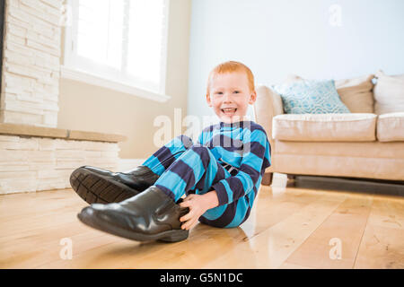 Kaukasische junge Schuhe des Vaters im Wohnzimmer Stockfoto