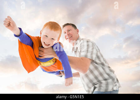 Kaukasische Vater und Sohn spielen Superheld Stockfoto