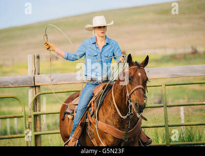 Kaukasische Cowgirl Lasso zu werfen, auf dem Pferderücken Stockfoto