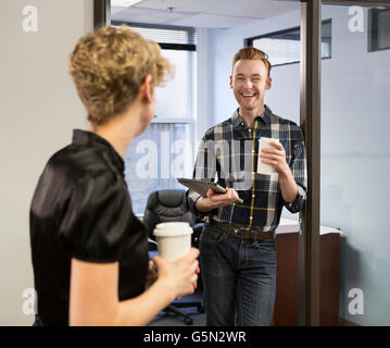 Kaukasische Geschäftsleute sprechen im Büro Stockfoto