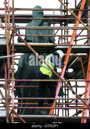 Historisches Schottland Lehrling Steinmetzer Liam Grubb, klettert auf Gerüste, während die Restaurierungsarbeiten an der verwitterten Statue von Robert the Bruce Statue auf dem Schlachtfeld von Bannockburn beginnen, Um die Statue vor dem 700. Jahrestag der Schlacht wiederherzustellen, wo Bruce angeblich die englische Armee von König Edward II besiegt haben soll, um einen unabhängigen Monarchen für Schottland zu sichern. Stockfoto