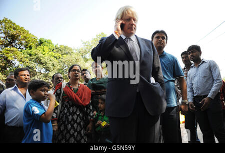 Der Londoner Bürgermeister Boris Johnson wird live von einem Londoner Radiosender interviewt, während er von Einheimischen am Tor von Indien in Mumbai umgeben ist, nachdem er Wirtschaftsführer an der Bombay Stock Exchange traf, Als Teil einer einwöchigen Tour durch Indien, wo er versucht, indische Unternehmen zu überzeugen, in London zu investieren. Stockfoto