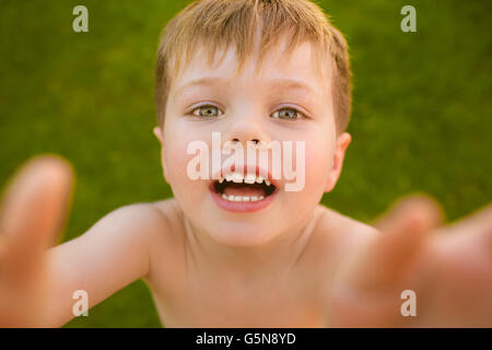 Kleiner Junge macht Selfie auf dem Rasen Stockfoto