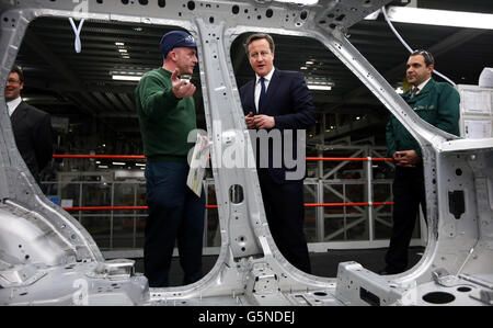 Premierminister David Cameron spricht mit JLR-Mitarbeiter Christopher Snape über den neuen Range Rover mit Aluminiumgehäuse im Jaguar Land Rover (JLR)-Werk Solihull. Stockfoto