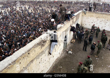 Es kommt zu Chaos, wenn afghanische Männer versuchen, sich ein Fußballspiel anzusehen, indem sie über die Wände des Olympiastadions in Kabul, Afghanistan, klettern. Das Spiel fand zwischen ISAF (International Security Assistance Force) und dem FC Kabul statt. Stockfoto