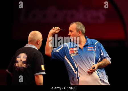 Phil Taylor im Einsatz gegen Robert Thornton während der World Darts Championship Ladbrokes.com im Alexandra Palace, London. Stockfoto