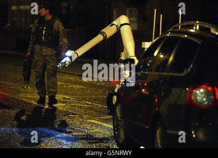 Ein Experte für die Entsorgung von Armeebomben zieht ein, um eine Sprengfalle zu untersuchen, die unter einem Polizeiauto in Belfast gefunden wurde. Stockfoto