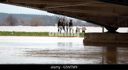 Eine Gruppe geht durch die überfluteten Felder im Schatten der Brücke bei Upton upon Severn, Worcestershire. Stockfoto