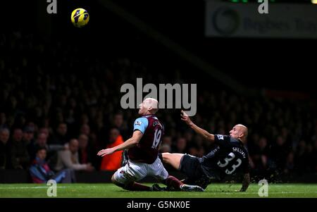 James Collins von West Ham United (links) lenkt den Ball in sein eigenes Netz für Liverpools drittes Tor unter dem Druck von Jonjo Shelvey aus Liverpool während des Barclays Premier League-Spiels in Upton Park, London Stockfoto