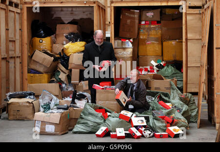 Nigel Cotton (rechts) Senior Investigator bei Trading Standards und Pat Corfield, vom Staffordshire County Council, suchen gefälschte Waren im Wert von bis zu &pound;15 Millionen, entdeckt nach einer Razzia auf dem Gelände in Birmingham durch Handelsstandards und Staffordshire Polizeibeamte am 6. Dezember. Stockfoto