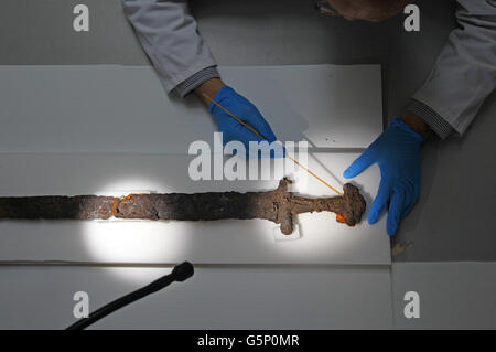 Dr. Paul Mullarkey vom Conservation Department des National Museum of Ireland, Collins Barracks, Dublin, inspiziert ein Wikingerschwert, das kürzlich zusammen mit anderen Artefakten in einem Moor in der Nähe des Flusses Shannon in Co. Offaly entdeckt wurde und derzeit von Experten im Museum konserviert wird. Stockfoto