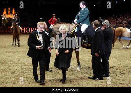 Die Herzogin von Cornwall überreicht der irischen Siegerin Cian O'Connor Splendor auf der London International Horse Show in Olympia die Trophäe „Christmas Pudding Stakes“. Stockfoto