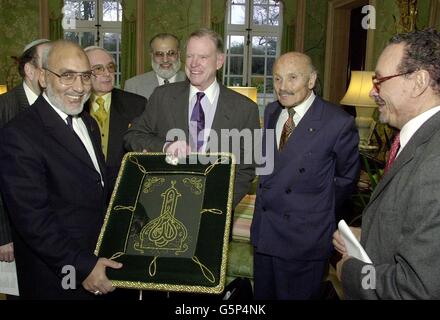 Der US-Botschafter in Großbritannien, William Farish (3. Rechts), nimmt einen islamischen Wandteppich von Dr. Hani El-Banna (links) an, der von Sir Sigmund Sternberg (2. Rechts) und Scheich Dr. Zaki Badawi (rechts) in seiner Londoner Residenz beobachtet wird. * der Botschafter unterhielt Mitglieder des britischen Forums für drei Glaubensrichtungen, das die christlichen, jüdischen und muslimischen Gemeinschaften im ganzen Land vertritt, und suchte nach Harmonie zwischen ihnen nach den Terroranschlägen vom 11. September letzten Jahres in Amerika. Stockfoto