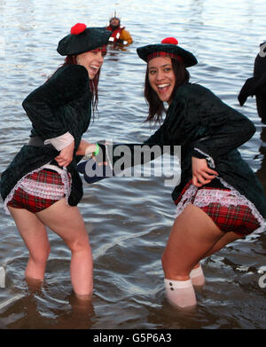 Schwimmer nehmen an der Loony Dook Neujahrsschwimmen im Fluss Forth in der Nähe der Forth Rail Bridge Teil. Stockfoto