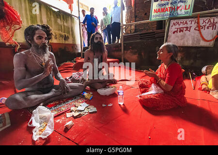 Guwahati, Assam, Indien. 22. Juni 2016. Eine ältere Frau bitten um Segen von einem Naga-Sadhu während der laufenden Ambubachi Mela (Ambubachi Festival) Kamakhya Temple.The Ambubachi Mela (Ambubachi Festival und Schicksal) ist eine jährliche hinduistische Festival im Kamakhya Tempel in Guwahati, Assam, Indien. Diese jährliche Mela wird gefeiert, während der Monsunzeit, die während der Assamese Monat Ahaar, um die Mitte des Juni fällt wenn Sonne Transit auf dem Tierkreis Mithuna, wenn der Fluss Brahmaputra Flut wird. Es ist die Feier des jährlichen Menstruation Kurses der Hindu-Göttin Kama Stockfoto