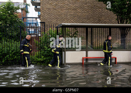 London, UK. 23. Juni 2016. Starker Regen verursacht Überschwemmungen in East London, Canning Town. Drei Feuerwehrleute waten durch die überfluteten Straße. Bildnachweis: ZEN - Zaneta Razaite / Alamy Live News Stockfoto