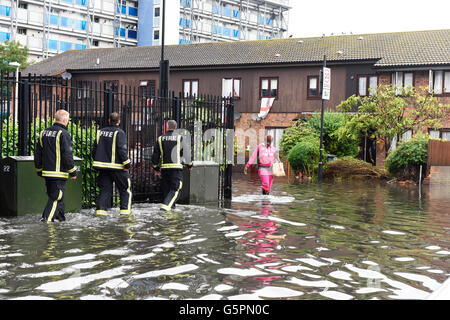London, UK. 23. Juni 2016. Starker Regen verursacht Überschwemmungen in East London, Canning Town. Drei Feuerwehrleute und ein lokaler Wohnsitz waten durch die überfluteten Straße. Bildnachweis: ZEN - Zaneta Razaite / Alamy Live News Stockfoto