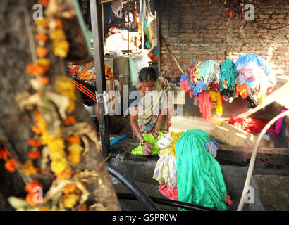 Waschmaschinen, lokal als dhobis bekannt, arbeiten im Freien, um Kleidung aus Mumbai Haushalte, Hotels und Krankenhäusern in der Mahalaxmi Dhobi Ghat (Waschplatz) im Mahalaxmi-Viertel von Mumbai zu waschen, Indien PRESSE VEREIN Foto. Bilddatum: Dienstag, 27. November 2012. In der Regel ein erblicher Beruf etwa 200 dhobi Familien aus der Kastengruppe Vannar a leben und arbeiten hier und arbeiten in der Regel von Tür zu Tür und sammeln schmutzige Wäsche aus Haushalten, Krankenhäusern und Hotels. Um zu verhindern, dass Kleidung verwechselt wird, markiert jeder dhobi ein einzigartiges Symbol oder Zeichen in schwarzer Tinte auf Kleidungsstücken Stockfoto