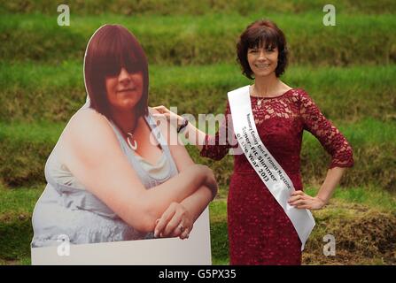 Rosemary Conley Diet and Fitness Magazine Super Fit Slimmer 2013, Debbie Plumpton, 43, aus Liversedge posiert mit einem Foto von sich selbst, bevor sie während eines Fotoanrufs in der Marriott County Hall, London, Gewicht verliert. Stockfoto