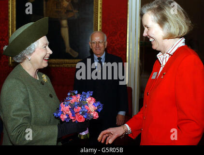 Die britische Königin Elizabeth II. (L) empfängt bei einem Empfang im St. James's Palace im Zentrum von London eine schicke Blumenpracht von Tessa Wells, der Sekretärin der Pilger. Stockfoto